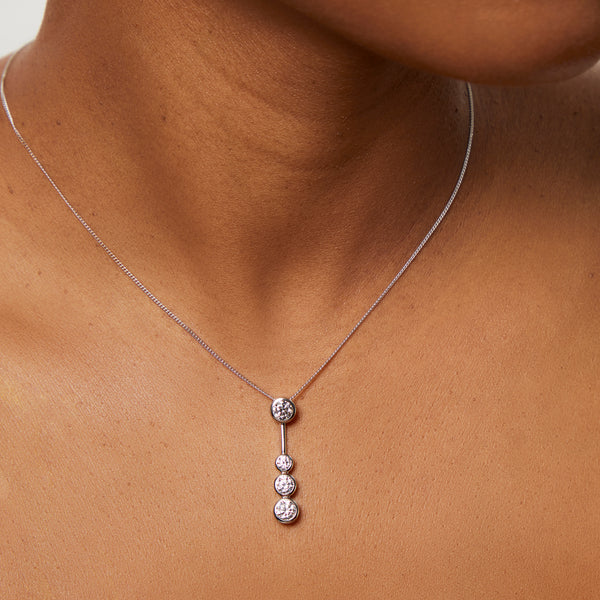 A sterling silver drop bubble pendant with four set cubic zirconia stones, suspended from a chain-JOOLS by Jenny Brown