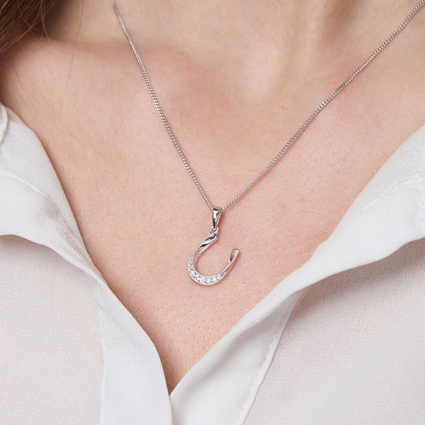 Tilted sterling silver horseshoe necklace set with shimmering white cubic zirconia.