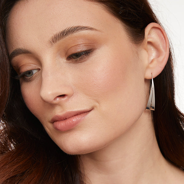 A pair of sterling silver sail shape pull through earrings.