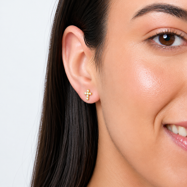 model wearing Dainty 18ct yellow gold vermeil cross studs set with small round cubic zirconia.