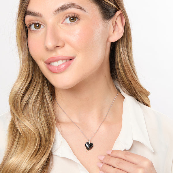 A sterling silver necklace with a black faceted heart-shaped pendant on a chain.