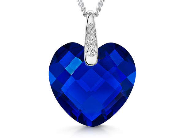A sterling silver necklace with a large faceted heart-shaped sapphire blue cubic zirconia pendant, accompanied by smaller clear cubic zirconia accents at the top.