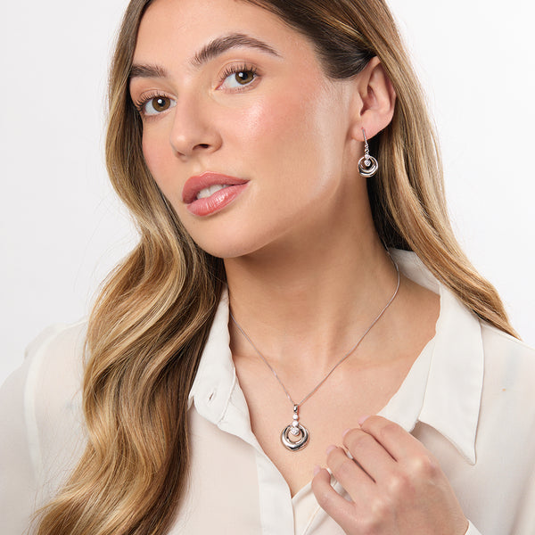 A pair of sterling silver circle earrings with three round cubic zirconia stones in a rhodium-plated finish.