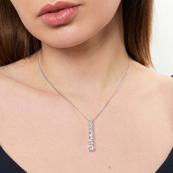A sterling silver pendant featuring graduated cubic zirconia stones in a vertical line, attached to a silver chain.