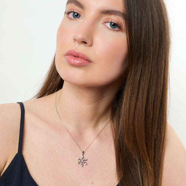 A sterling silver pendant in the shape of a snowflake, adorned with round cubic zirconia stones,-JOOLS by Jenny Brown
