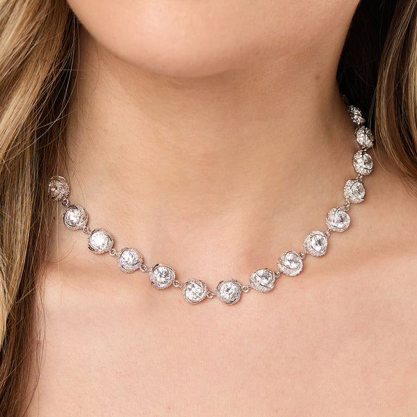 A sterling silver necklace with a twisted chain design and round cubic zirconia stones set in a pave setting.