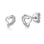 Load image into Gallery viewer, A pair of sterling silver half-offset heart stud earrings with cubic zirconia accents.-JOOLS by Jenny Brown