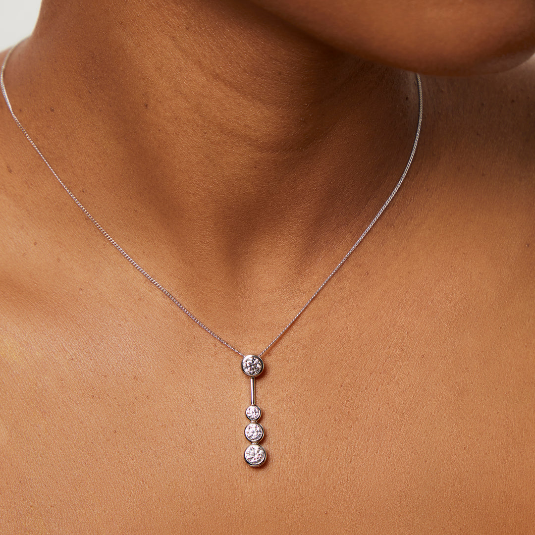 A sterling silver drop bubble pendant with four set cubic zirconia stones, suspended from a chain-JOOLS by Jenny Brown