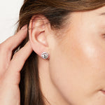 Load image into Gallery viewer, A pair of sterling silver halo style stud earrings with a central cubic zirconia stone surrounded by smaller cubic zirconia stones, rhodium finished-JOOLS by Jenny Brown
