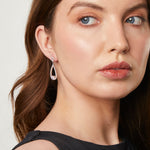Load image into Gallery viewer, A pair of sterling silver teardrop earrings with a single cubic zirconia stone in the center, surrounded by smaller pave-set cubic zirconia stones.-JOOLS by Jenny Brown
