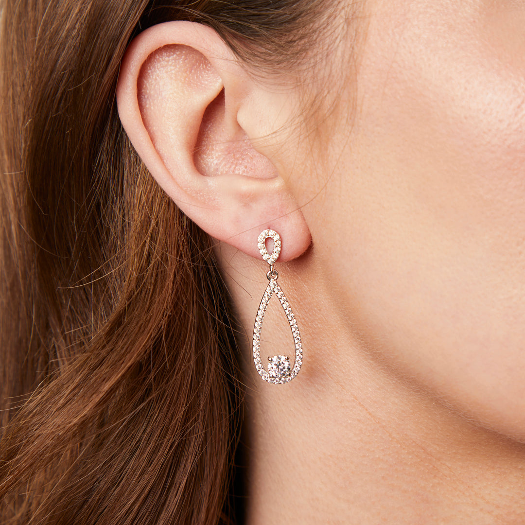 A pair of sterling silver teardrop earrings with a single cubic zirconia stone in the center, surrounded by smaller pave-set cubic zirconia stones.-JOOLS by Jenny Brown