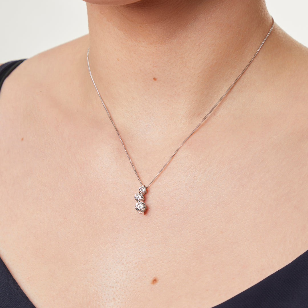A sterling silver pendant with three cubic zirconia stones arranged in a curved drop design-JOOLS by Jenny Brown