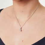 Load image into Gallery viewer, A sterling silver pendant with three cubic zirconia stones arranged in a curved drop design-JOOLS by Jenny Brown
