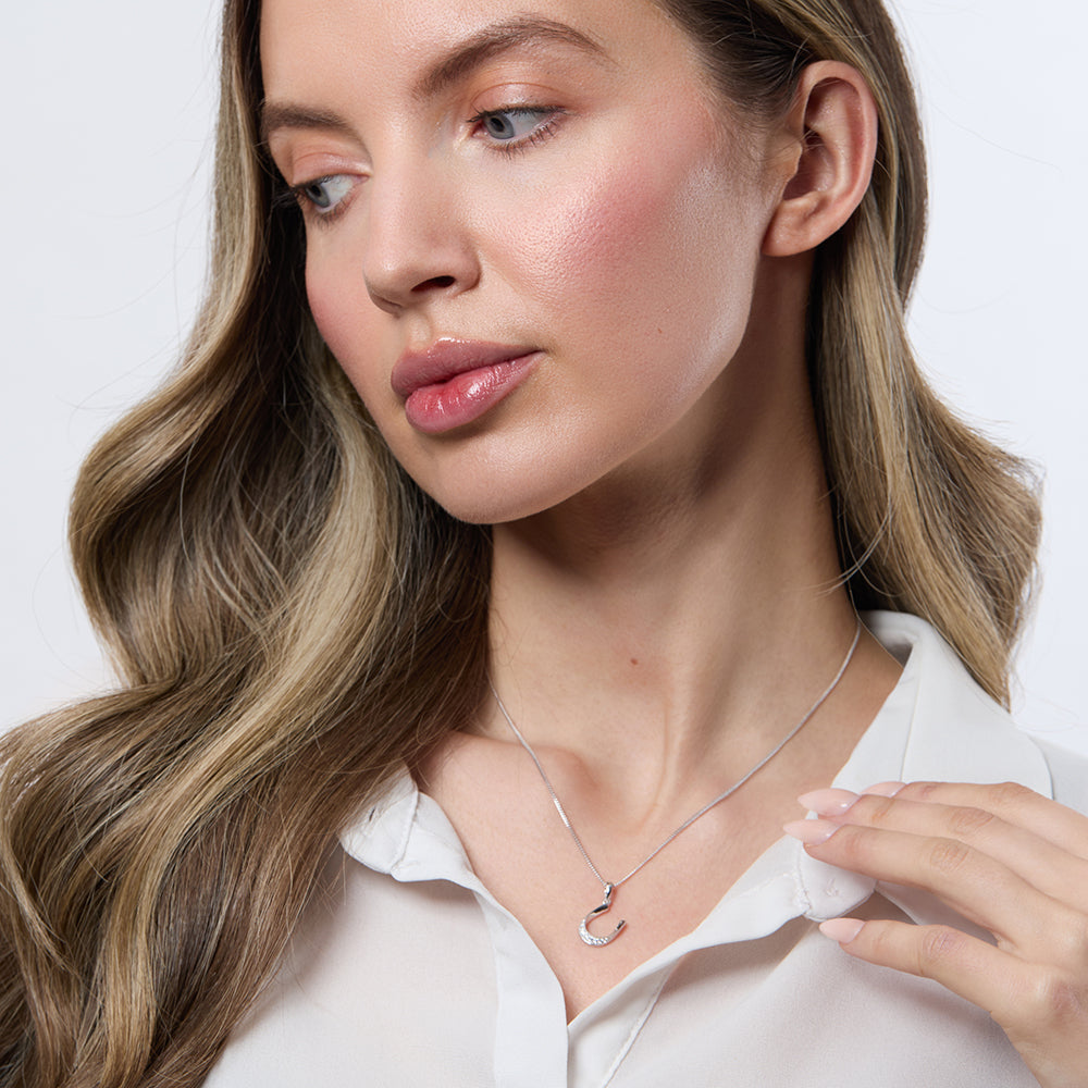Tilted sterling silver horseshoe necklace set with shimmering white cubic zirconia.