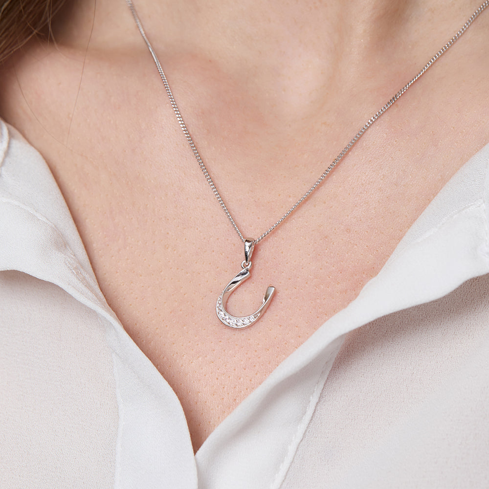Tilted sterling silver horseshoe necklace set with shimmering white cubic zirconia.
