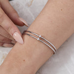 Load image into Gallery viewer, Model wrist showing  sterling silver bangle bracelet with a two-row solid pattern set with cubic zirconia stones-JOOLS by Jenny Brown
