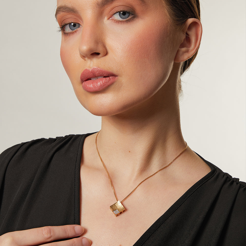 A yellow gold diamond offset textured square pendant on a 16-inch box chain.