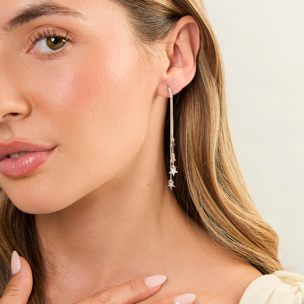 A pair of sterling silver chain drop earrings with star designs, rhodium finished for tarnish resistance, with gift packaging.