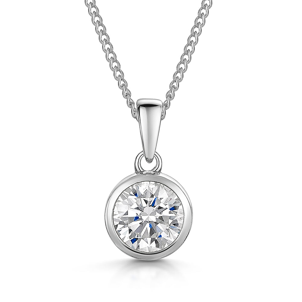 A sterling silver solitaire pendant with a round cubic zirconia stone in a rub over setting, displayed on a silver chain.-JOOLS by Jenny Brown