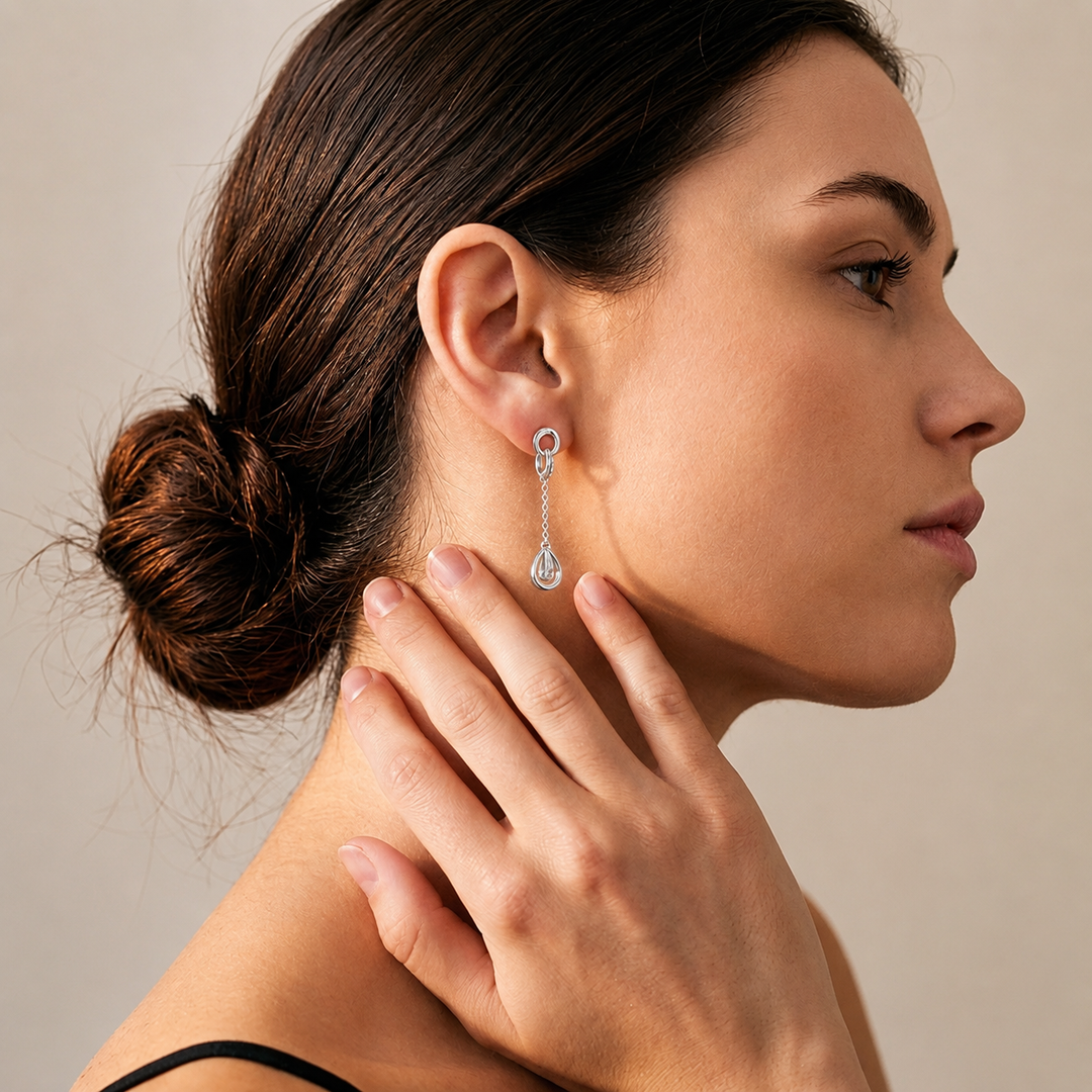 model waering Art Deco-style sterling silver drop earrings featuring a sparkling oval AAA cubic zirconia center