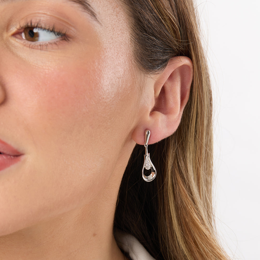 A pair of sterling silver open peardrop earrings with inner lines of cubic zirconia, featuring a hypoallergenic rhodium finish.