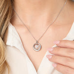 Load image into Gallery viewer, A sterling silver pendant with a cubic zirconia suspended heart centre, rhodium finished, on a silver chain.
