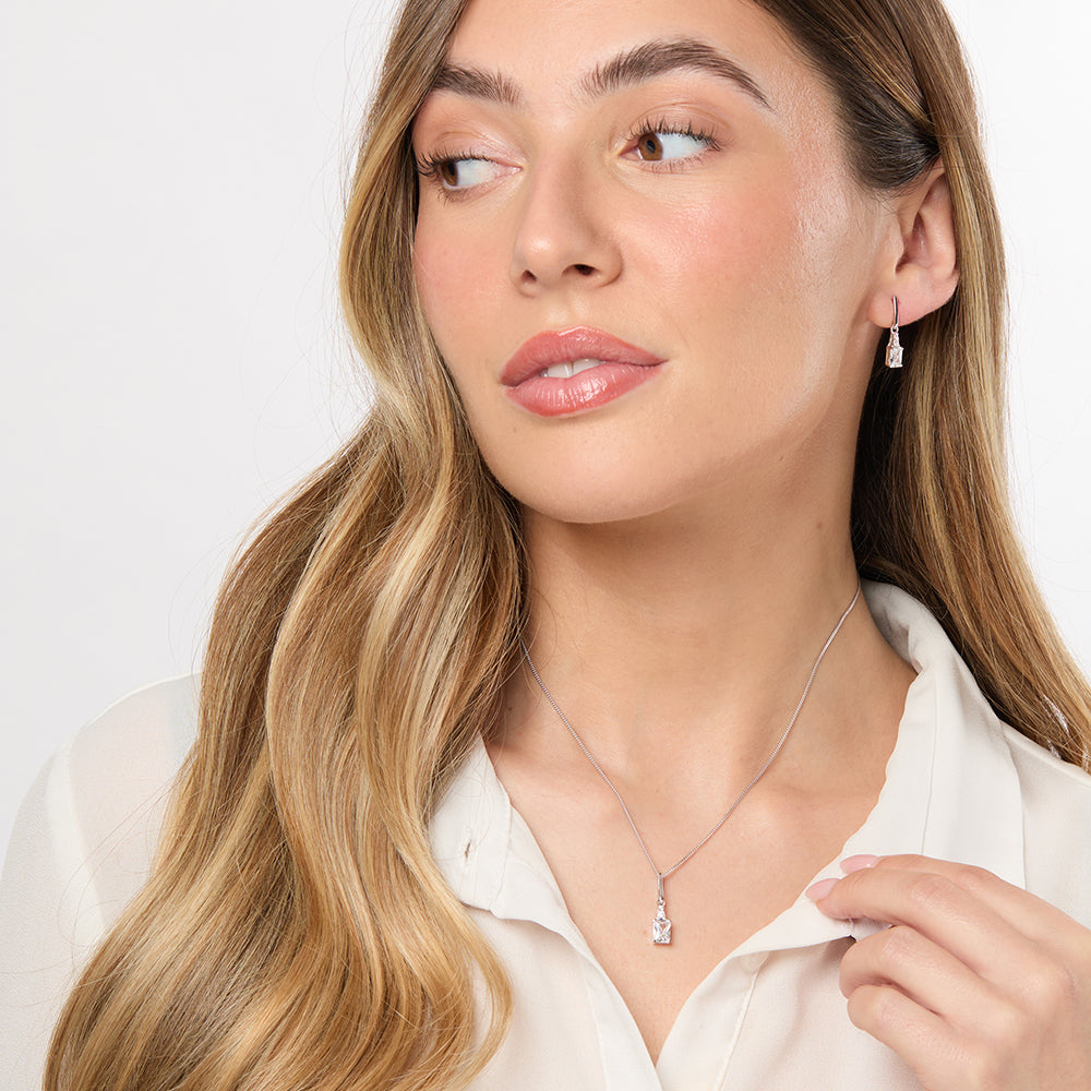 Sterling Silver Pendant with a radiant cut cubic zirconia centerpiece, surrounded by smaller round CZs, attached to a sterling silver long bale and a chain.- JOOLS by Jenny Brown