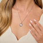 Load image into Gallery viewer, A sterling silver circle swirl pendant with a halo setting of cubic zirconia stones, displayed on a silver chain-JOOLS by Jenny Brown
