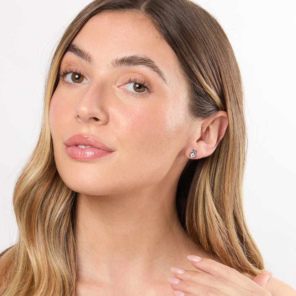 A pair of sterling silver stud earrings with a ribbon design featuring white cubic zirconia center stones-JOOLS by Jenny Brown