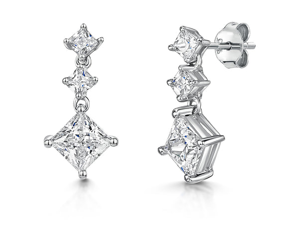 A pair of sterling silver drop earrings featuring three square cubic zirconia stones, with the larger stone at the top and the smaller at the bottom-JOOLS by Jenny Brown