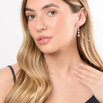 Load image into Gallery viewer, A pair of sterling silver drop earrings featuring five cubic zirconia stones, with a rhodium finish for tarnish resistance-JOOLS by Jenny Brown
