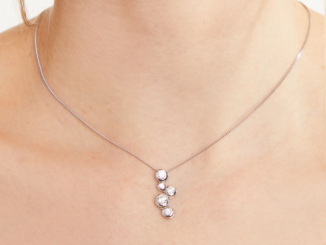 A sterling silver pendant featuring five cubic zirconia stones in a graduated bubble design, attached to a silver chain-JOOLS by Jenny Brown