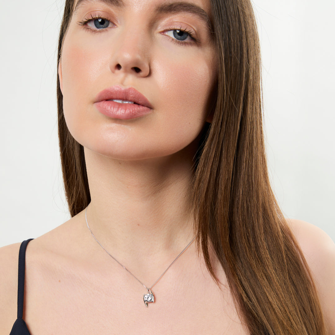 A sterling silver 2 carat  solitaire pendant with a round cubic zirconia stone offset held by two silver bars, on a chain-JOOLS by Jenny Brown