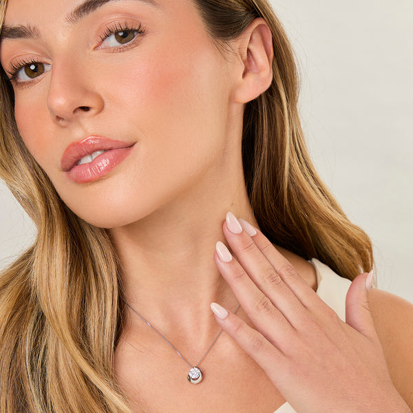 A sterling silver circle necklace with a cubic zirconia set twist feature on a chain.-JOOLS by Jenny Brown