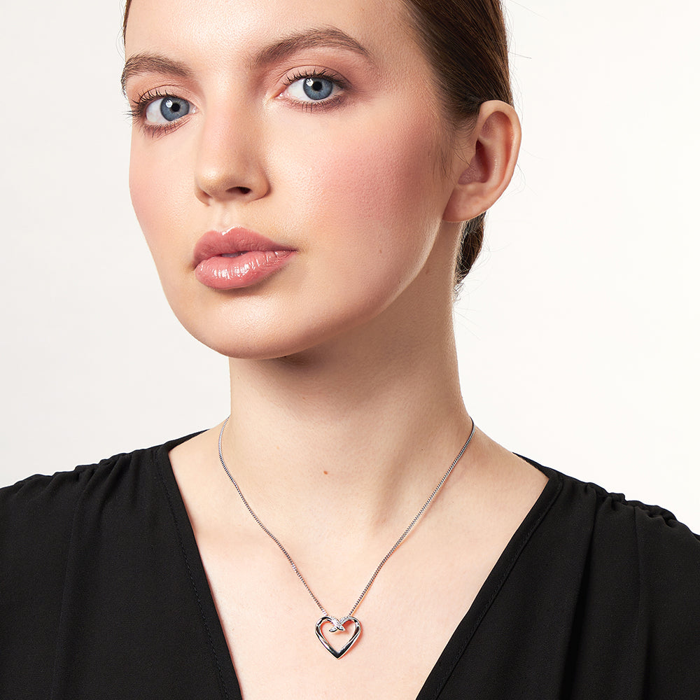 A sterling silver heart-shaped pendant with overlapping cubic zirconias, attached to a silver chain-JOOLS by Jenny Brown