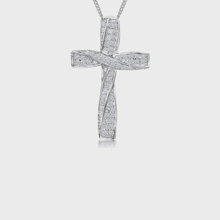 A sterling silver twisted cross pendant pave set with  white cubic zirconia stones, accompanied by a silver curb chain.