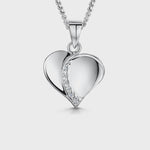 Load and play video in Gallery viewer, A sterling silver polished heart pendant with a cubic zirconia stone in the center-JOOLS by Jenny Brown
