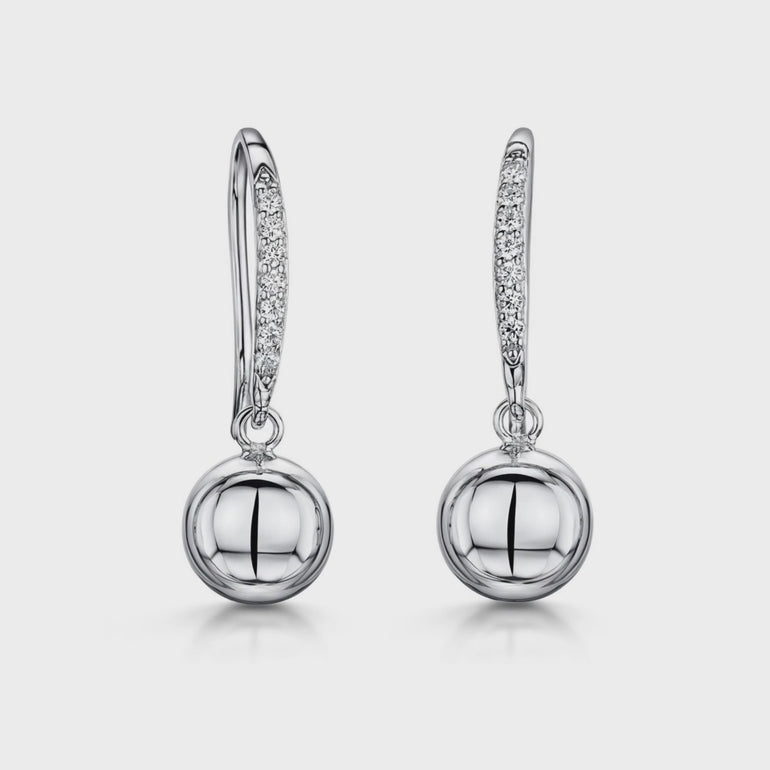 A pair of sterling silver fishhook earrings featuring a plain silver ball drop with pave set cubic zirconia stones