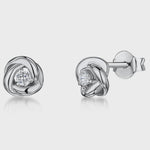 Load and play video in Gallery viewer, A pair of sterling silver knot stud earrings with cubic zirconia in the center-JOOLS by Jenny Brown
