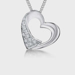 Load and play video in Gallery viewer, A sterling silver heart-shaped pendant with polished and satin finishes, adorned with offset cubic zirconias, displayed on a chain.
