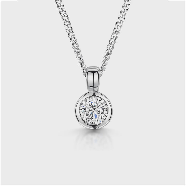 A sterling silver solitaire pendant with a round  quarter carat cubic zirconia stone, attached to a silver chain.