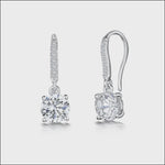Load and play video in Gallery viewer, A pair of sterling silver fishhook earrings with a central cubic zirconia stone and smaller stones set in the bale. The earrings are rhodium finished for tarnish-free wear.
