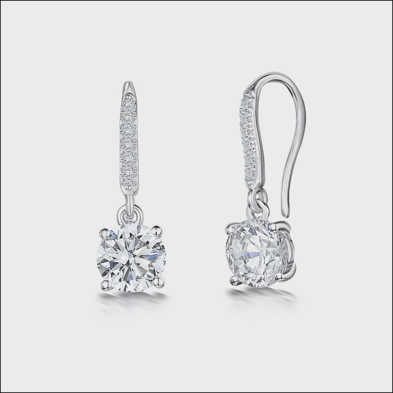 A pair of sterling silver fishhook earrings with a central cubic zirconia stone and smaller stones set in the bale. The earrings are rhodium finished for tarnish-free wear.