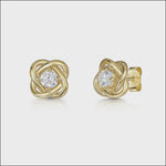 Load and play video in Gallery viewer, A pair of yellow gold woven knot stud earrings with cubic zirconia centers.
