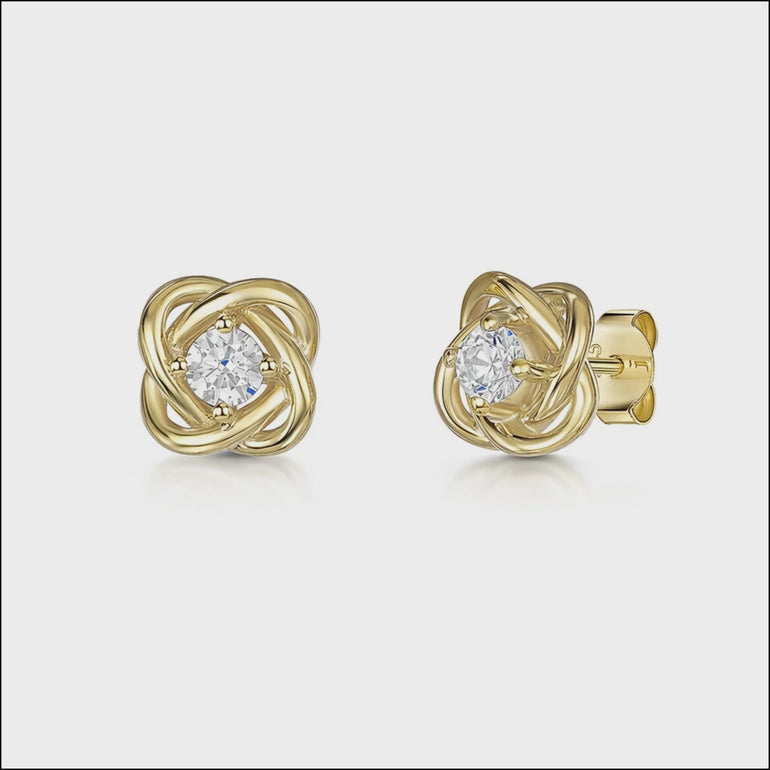 A pair of yellow gold woven knot stud earrings with cubic zirconia centers.