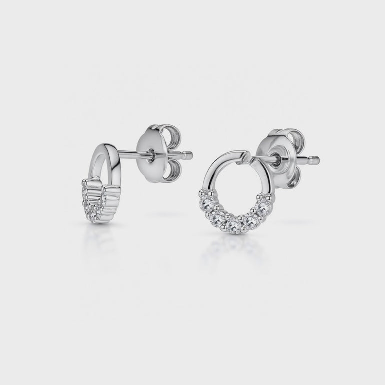 A pair of sterling silver circle earrings with white zirconia stones set in a half circle design.