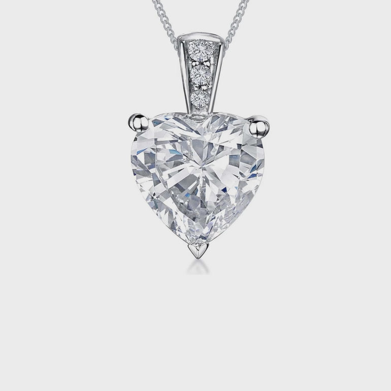 A sterling silver pendant with a cubic zirconia heart-shaped stone, mounted on a silver chain. JOOLS By Jenny Brown