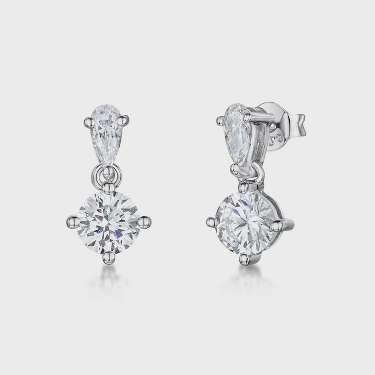 A pair of sterling silver teardrop bale earrings with a single cubic zirconia centerpiece set in a teardrop design.