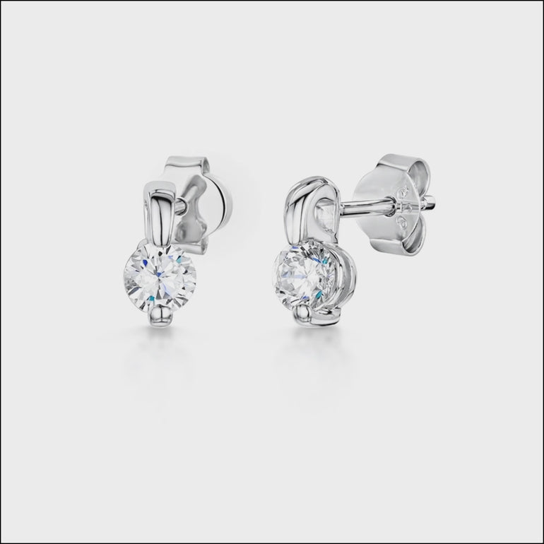 A pair of sterling silver stud earrings with a claw setting and cubic zirconia stones, displayed on a white background.