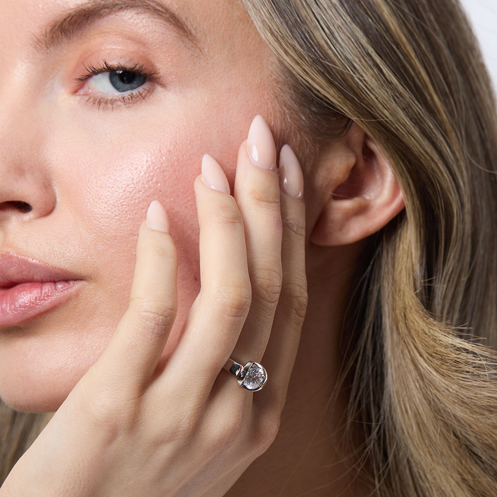 A sterling silver solitaire ring with an open setting featuring a round cubic zirconia stone.